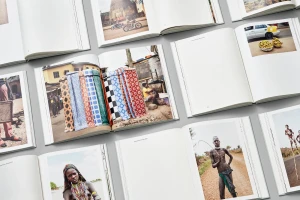 Multiple open photography books displaying colorful cultural portraiture and street scenes arranged on grey surface
