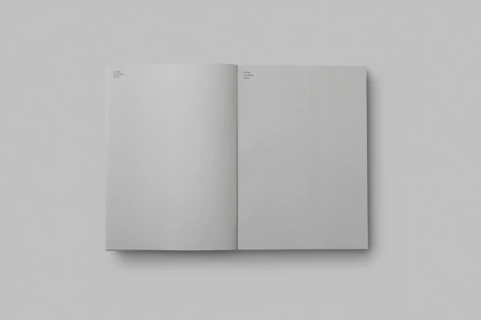 Open book with blank pages in a studio setting, featuring soft lighting and a clean background, ideal for graphic design mockups.