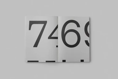 Open book layout featuring large black sans-serif numerals on a pale grey background, designed by OK-RM