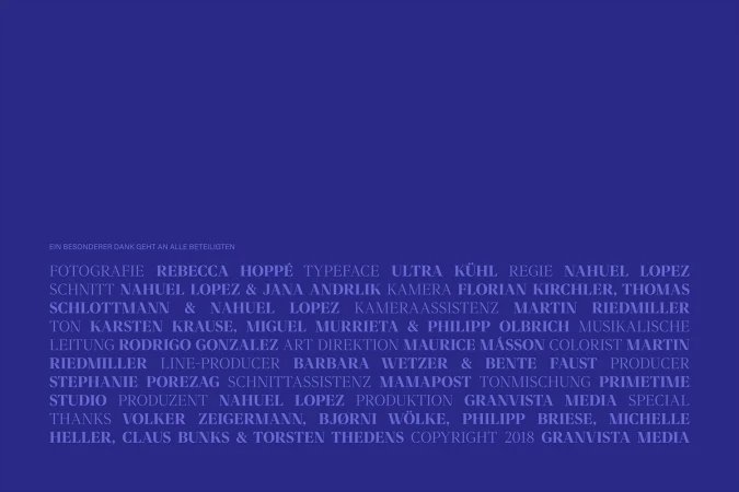 End credits display in indigo, listing production staff, copyright details, and acknowledgments on a solid-color background.