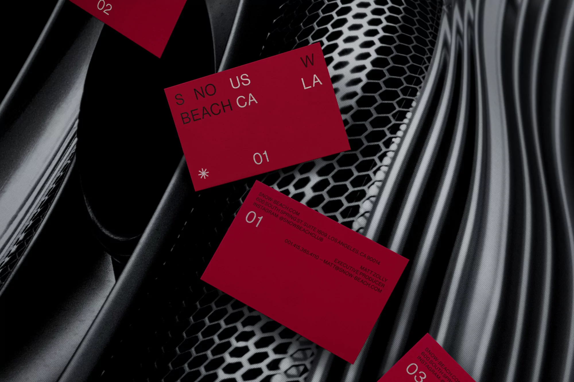 Eye-level shot of red cards with white text overlapping against a black and grey patterned background; the cards have the numbers 01-03.