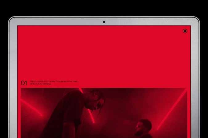 Laptop screen showing Travis Scott and Nav music video 'Beibs in the Trap' against a red background with neon lights.