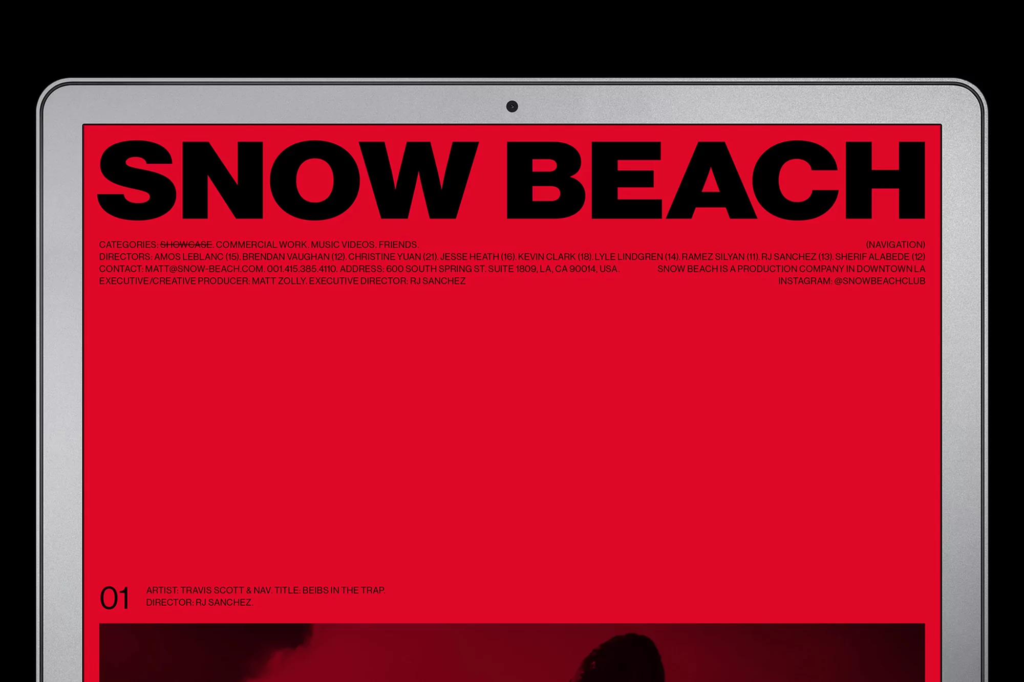 Website for Snow Beach production company displayed on an Apple laptop screen, set against a black background, simple composition.