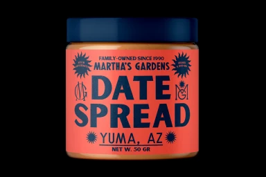 A jar of Martha's Gardens date spread featuring a red label with bold blue typography against a black background.