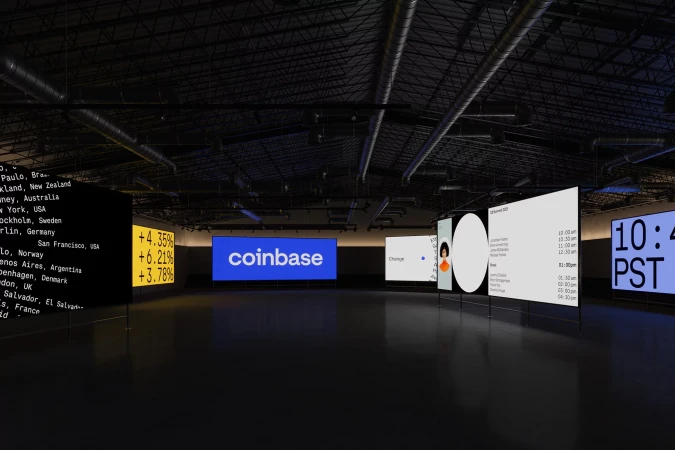 Large screens display data, logos, and graphics in a dark, spacious hall with a high ceiling, reflecting on the shiny floor.