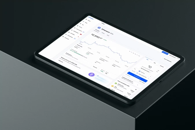Tablet displaying cryptocurrency data on a dark gray surface, showing line graphs and market information for Ethereum (ETH).