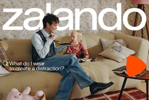 Man and toddler sitting on a beige sofa in a living room for a Zalando campaign, photographed by Rosie Marks.