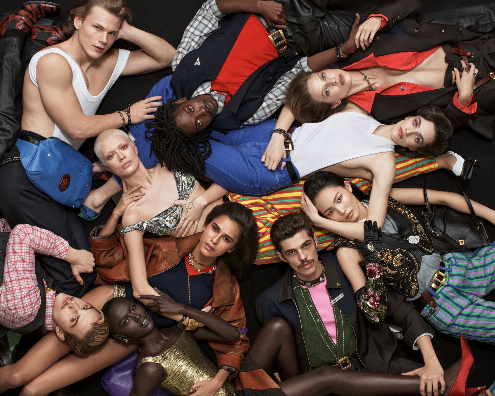 Diverse group of fashion models in stylish clothes posing together on a dark background. High-fashion, modern, and fashionable. 
