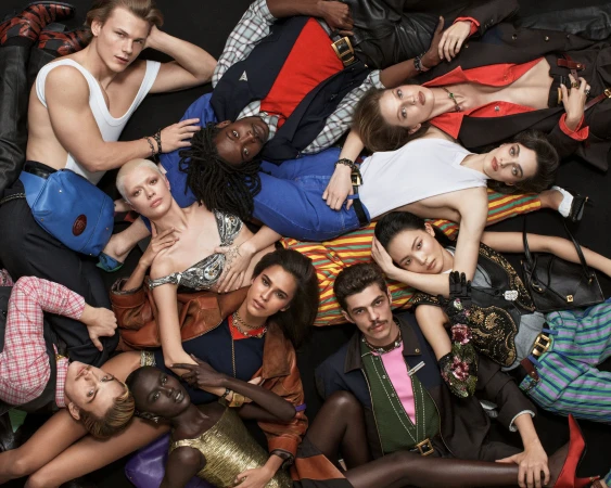 Diverse group of fashion models in stylish clothes posing together on a dark background. High-fashion, modern, and fashionable. 