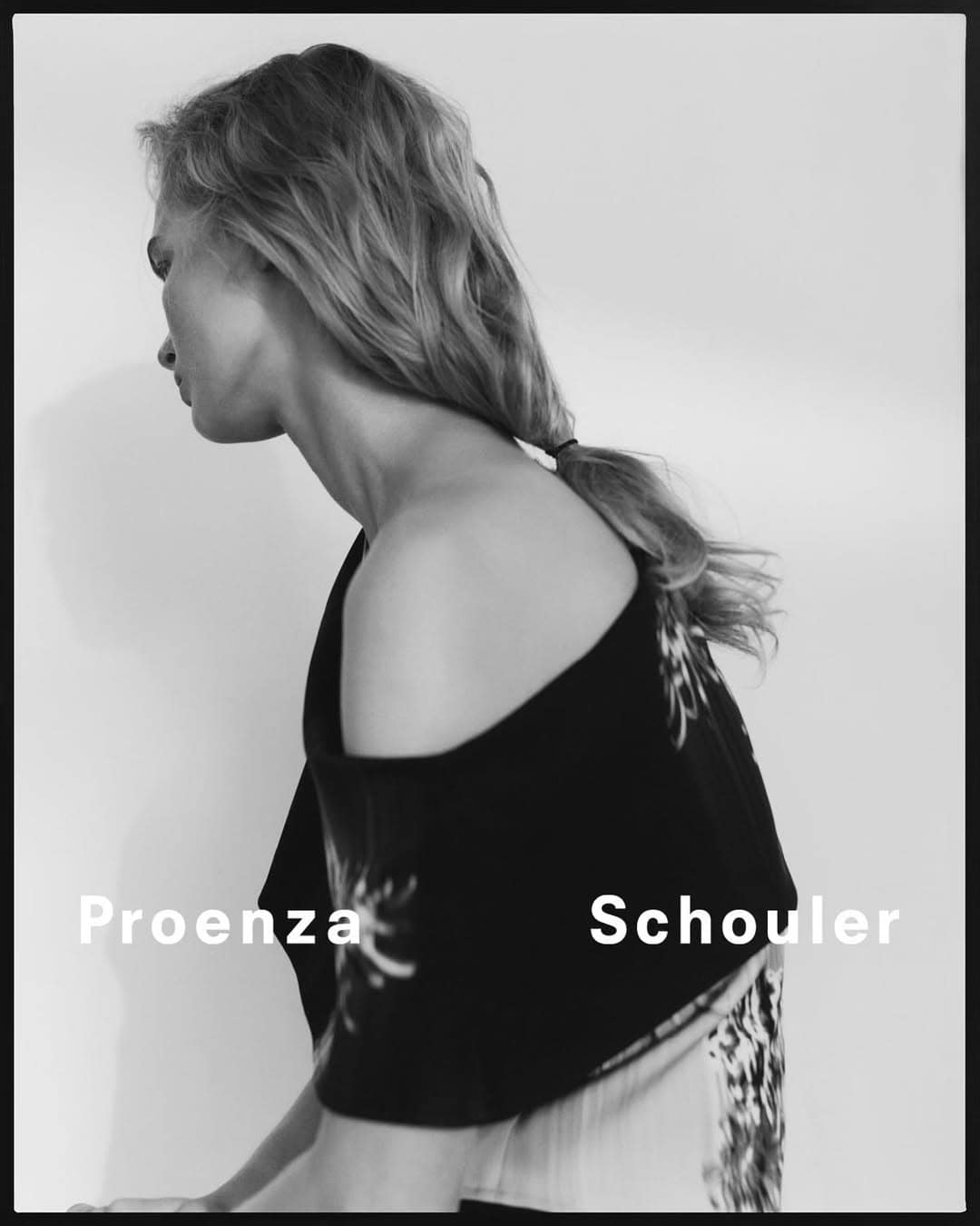 Monochrome side-view of an adult female wearing a patterned top, showcasing fashion and style in a studio setting with branding present.