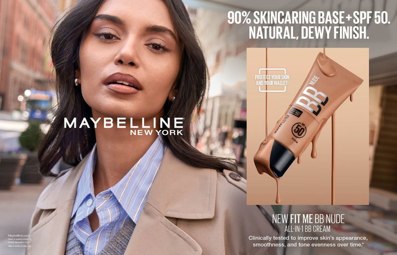 A woman models for a Maybelline New York ad, promoting Fit Me BB Nude All-in-1 BB Cream with SPF 50, in an outdoor urban setting.