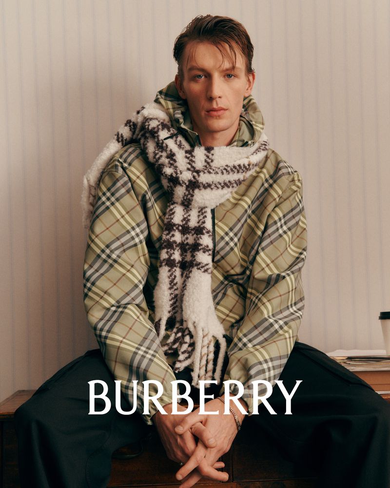 Portrait of a male model wearing a green plaid jacket and a white patterned scarf for Burberry