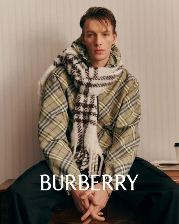 Portrait of a male model wearing a green plaid jacket and a white patterned scarf for Burberry