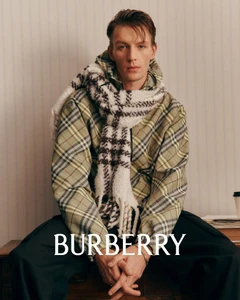 Portrait of a male model wearing a green plaid jacket and a white patterned scarf for Burberry