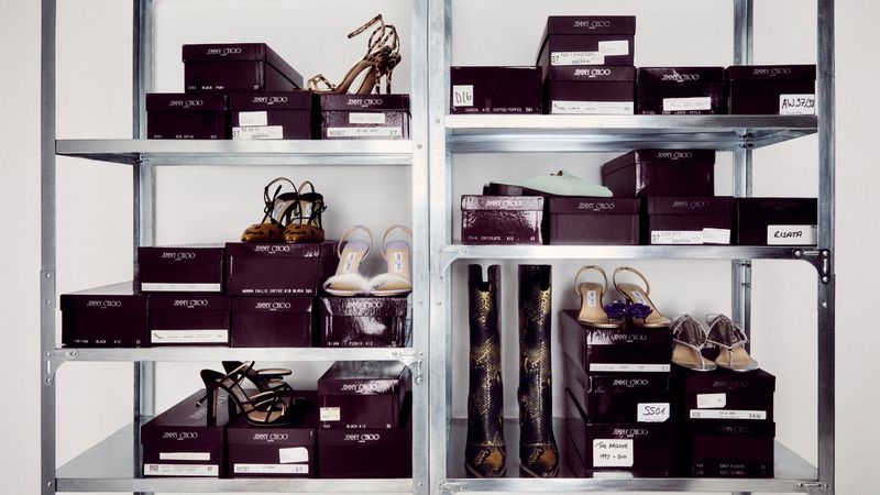Shelves filled with Jimmy Choo shoe boxes and shoes, showcasing a variety of high heels and boots in a well-organized display.