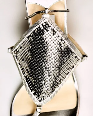 Close-up of a metallic silver stiletto sandal with diamond mesh upper by Jimmy Choo on white background