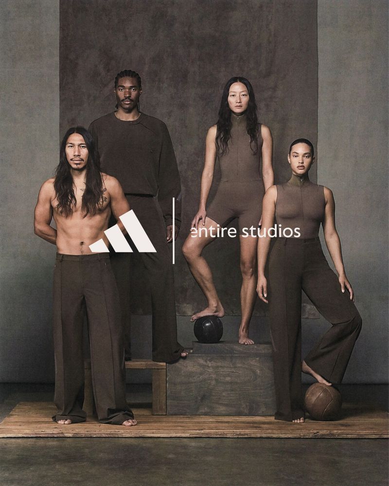 Four diverse models pose indoors in coordinating brown sportswear with geometric Adidas logo against a neutral backdrop.