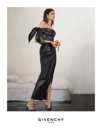Kaia Gerber wearing an off-the-shoulder black leather dress with a large bow detail for Givenchy Summer 2026