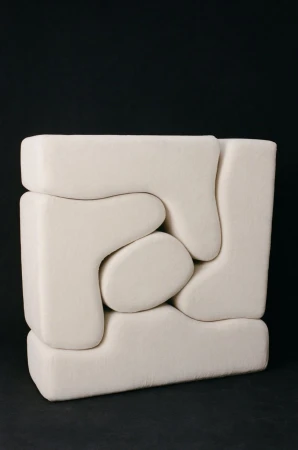 Abstract geometric sculpture in off-white with interlocking shapes against a dark background, creating a modern and minimalist aesthetic.