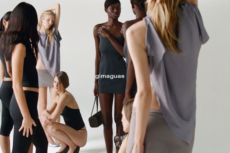Diverse group of women in neutral-toned clothing posing in a bright photo studio. Fashion shoot emphasizing minimalist style and natural light.