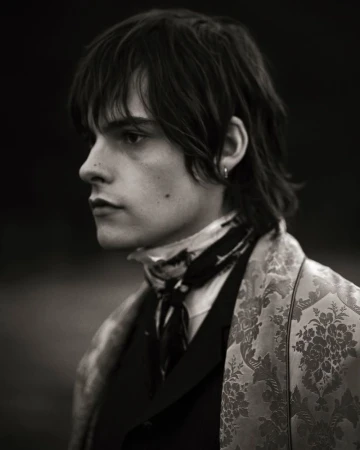 Portrait of male model Arthur Hargous in a patterned jacket and dark scarf for Ann Demeulemeester