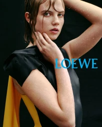 Wet-haired woman in a black top with yellow backing posing against a black seamless background for Loewe S/S 2026