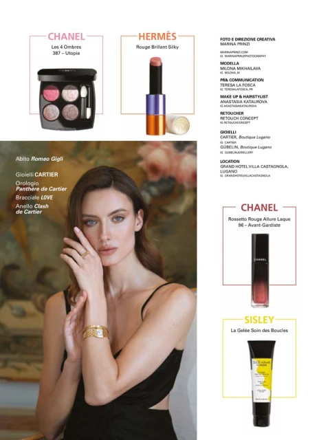 Advertisement featuring a woman with jewelry and makeup products from Chanel, Hermès, Sisley, and Cartier against a soft backdrop.