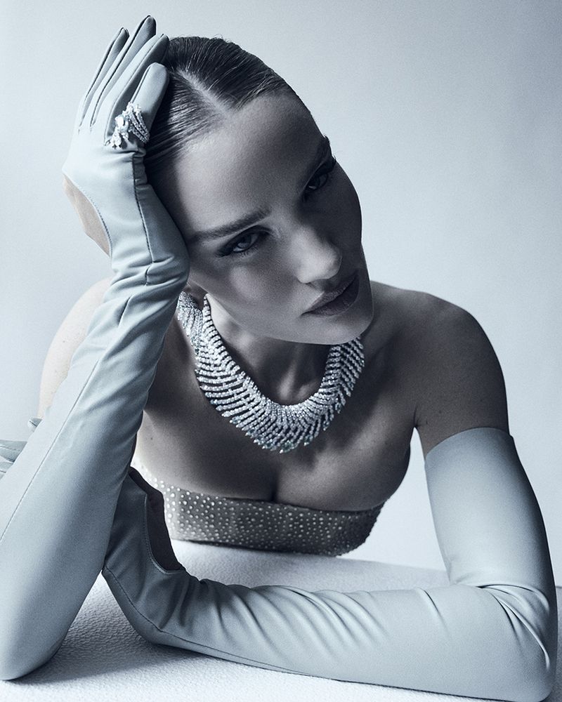 Elegant woman in gloves and diamond necklace. Posing fashion beauty shot with clean studio lighting and soft color palette.