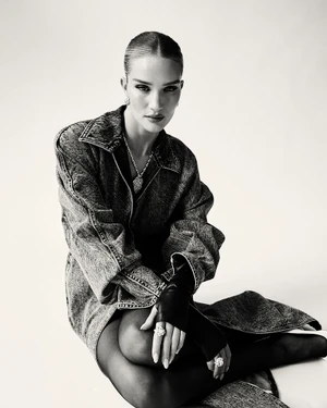 Model Rosie Huntington Whiteley wearing an acid-wash denim jacket and leather gloves against a plain white background