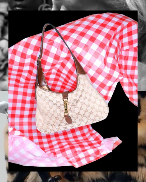 Gucci handbag with G monogram pattern and brown leather trim displayed on red and white checkered textile against a black backdrop.