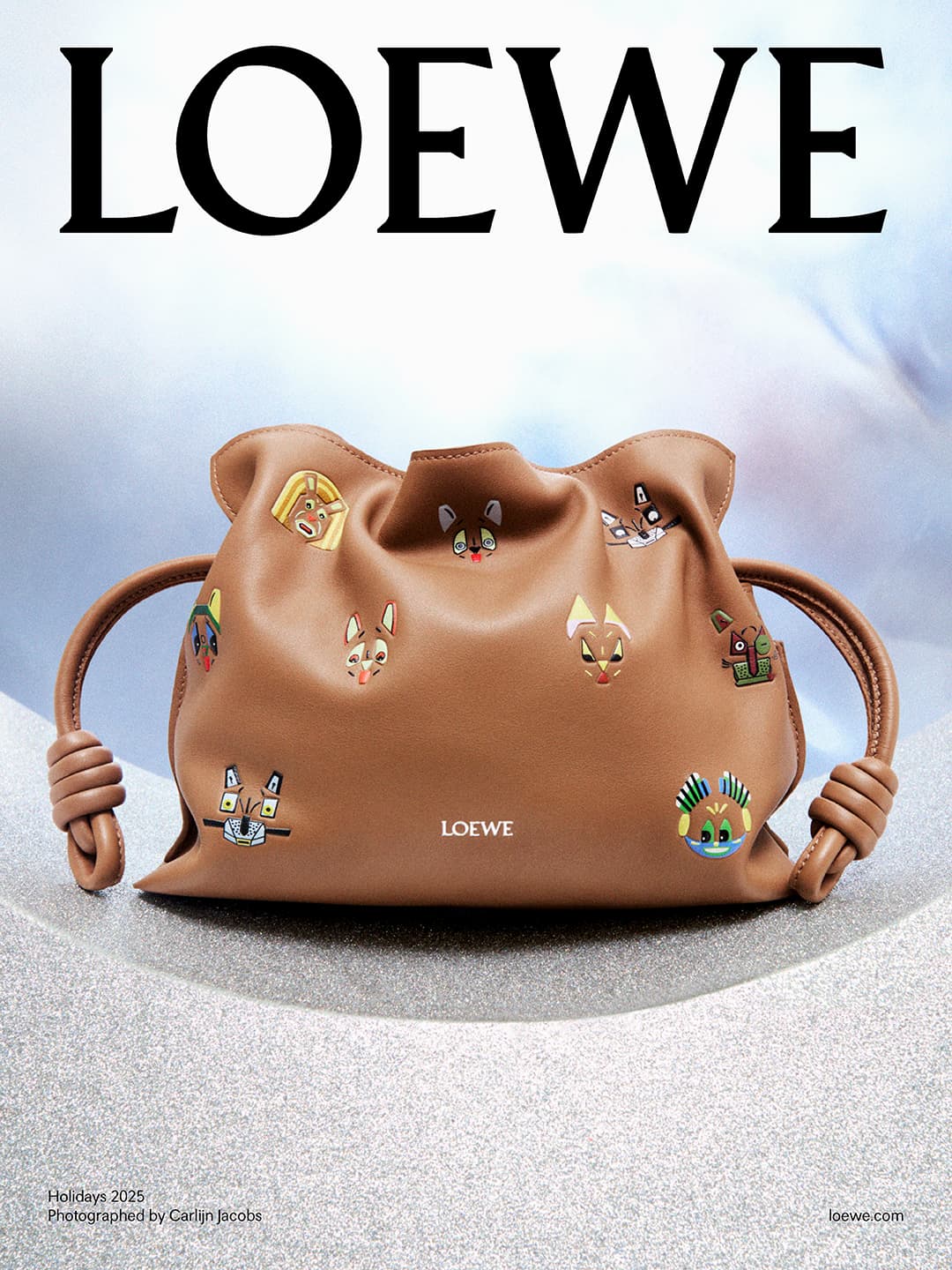 Loewe purse with cartoon animal embroidery on a gradient gray and blue background, showcasing a blend of fashion and playful design.