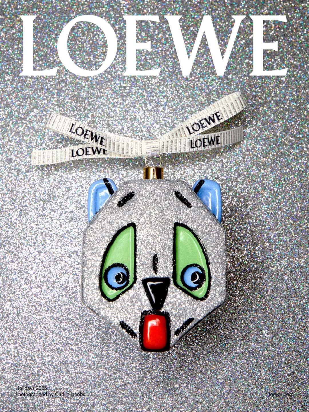 Silver glittery panda bear ornament by Loewe, displayed on a matching silver glittery background with white logo ribbon.