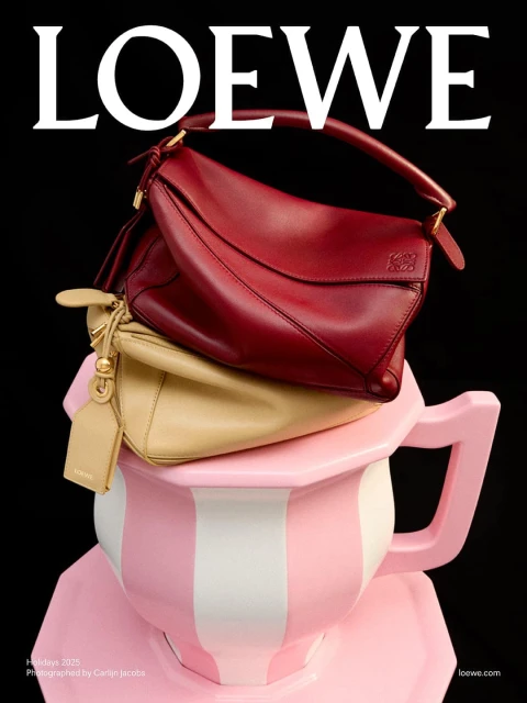 Loewe handbag display on a pink and white teacup against a black background, highlighting luxury fashion and creative presentation.