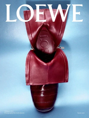 Close-up product shot of a burgundy leather boot with folded collar against a blue background.