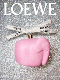 Pink glitter elephant ornament with a branded ribbon against a sparkly silver background for Loewe.