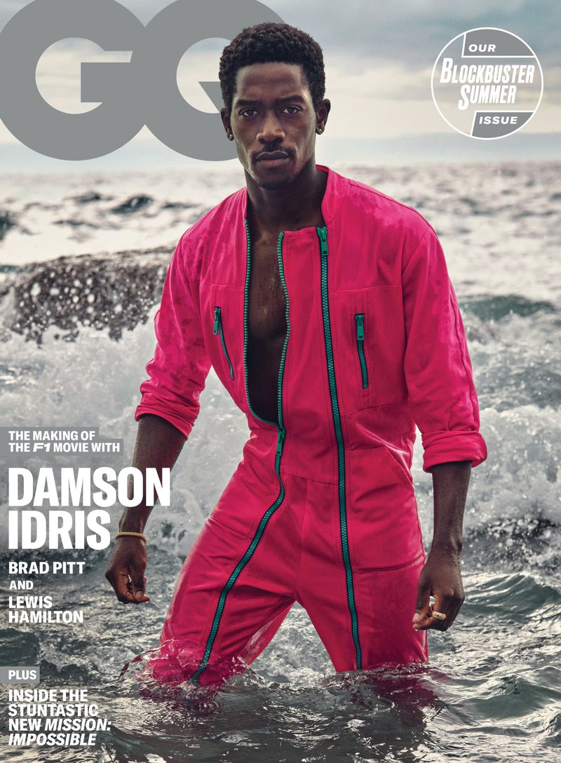 Magazine cover featuring Damson Idris in a pink jumpsuit, standing in ocean waves. GQ logo and summer blockbuster issue text visible.