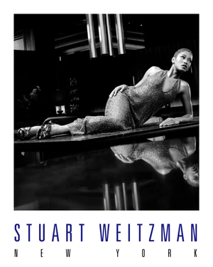 Keke Palmer reclining on a reflective surface wearing a sequined dress for Stuart Weitzman Holiday 2025 campaign.