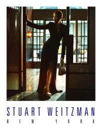 Keke Palmer wearing a black dress and platform heels holding a handbag in a hotel doorway for Stuart Weitzman.