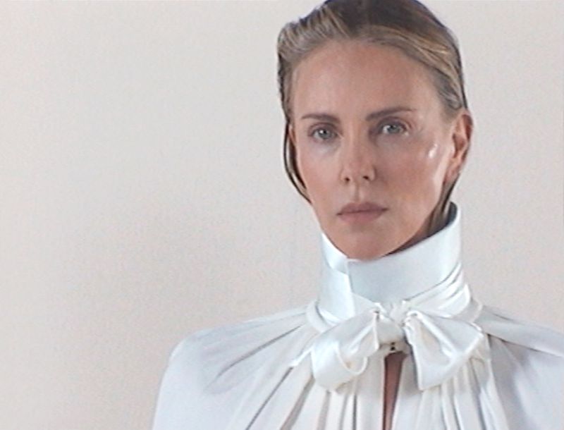 Elegant portrait of a woman in white high-collar dress, close-up shot with shallow depth of field, captured in a bright, minimalist photo studio.