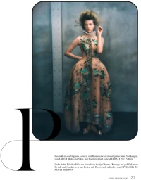 Model Melinda Kiss in an embroidered organza gown standing against an industrial wall for Harper's Bazaar Germany