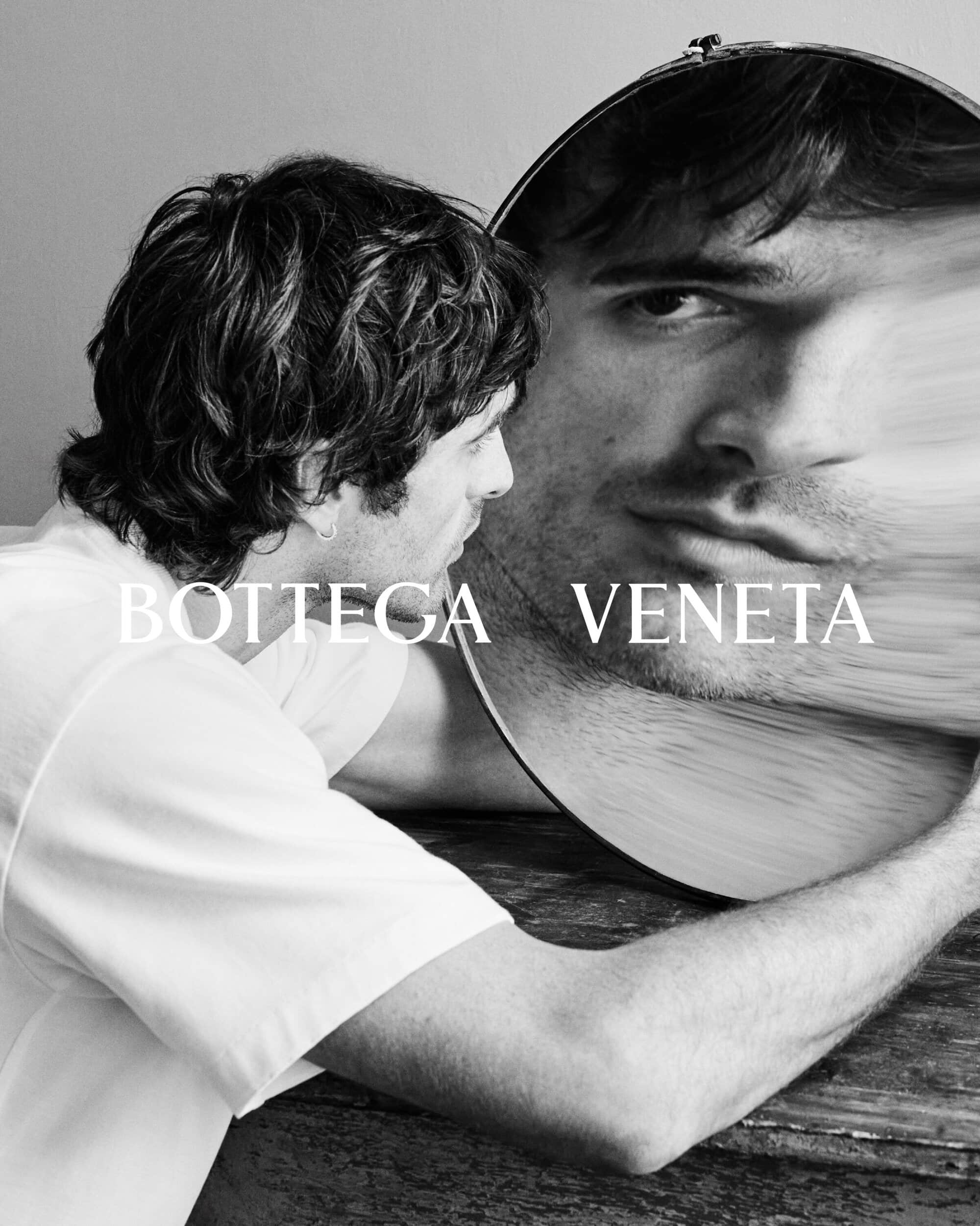 Jacob Elordi wearing a white t-shirt looking into a distorted circular mirror for Bottega Veneta