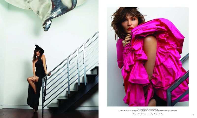 Fashion editorial shot: A model poses on stairs in a black dress and witch hat, alongside a model in a vibrant pink ruffled dress.