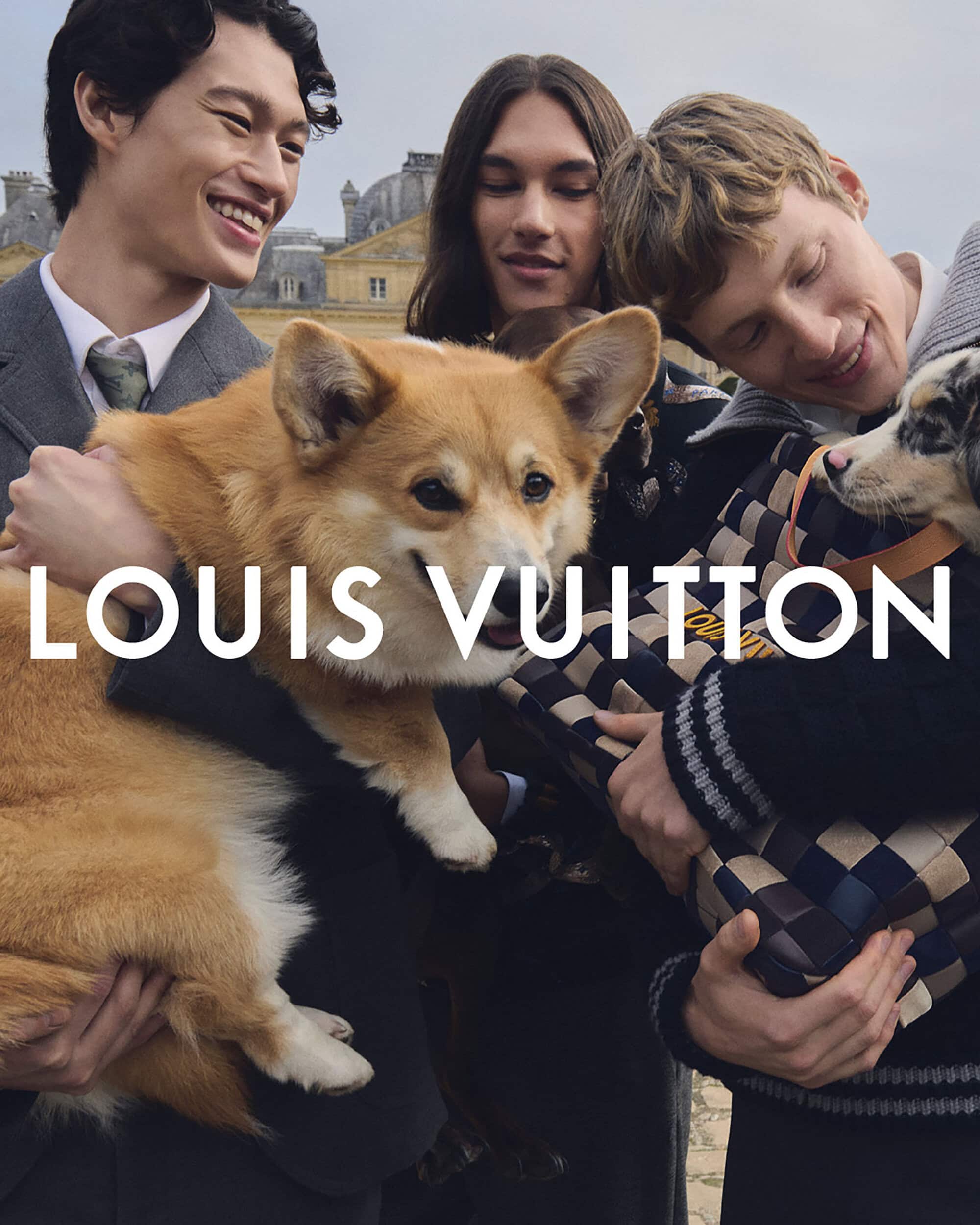 Fashion advertisement with three young adult men and two dogs, set against a backdrop of a historic building and overcast sky.