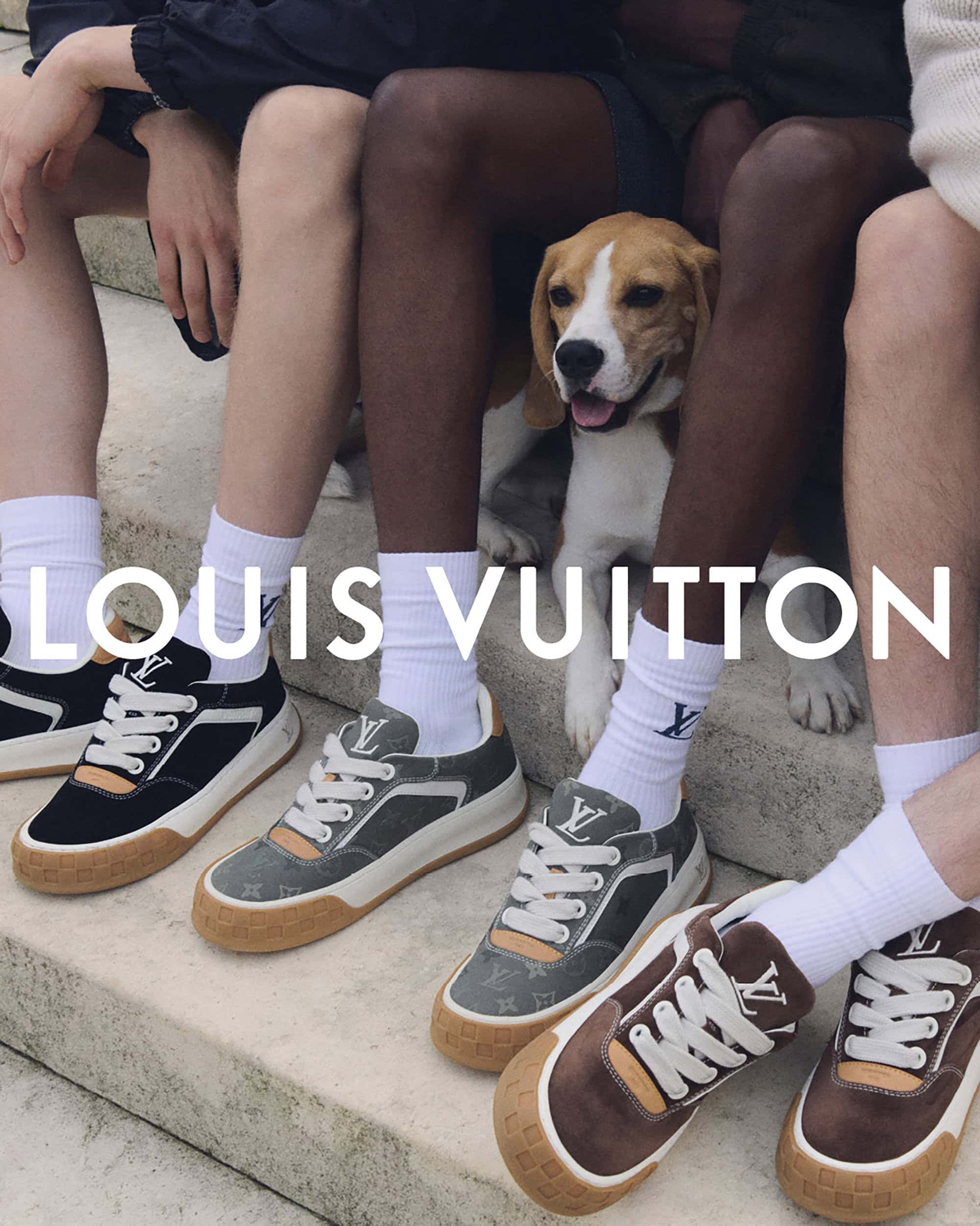 Three pairs of Louis Vuitton sneakers are displayed in a low-angle shot alongside three people and a beagle, creating a casual, fashionable scene.