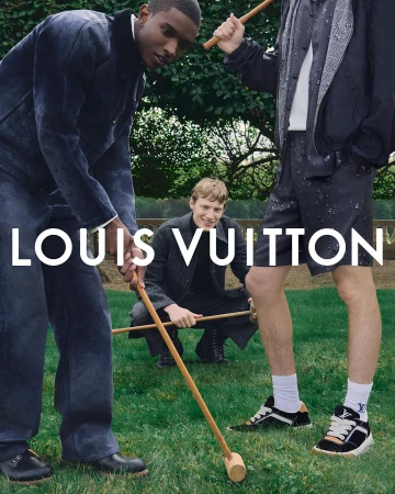Three stylish men play croquet in an outdoor grassy setting, showcasing fashion and leisure with the Louis Vuitton logo prominently displayed.