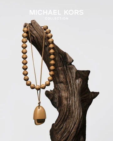 Beaded leather statement necklace draped over a textured wooden branch against a neutral white background