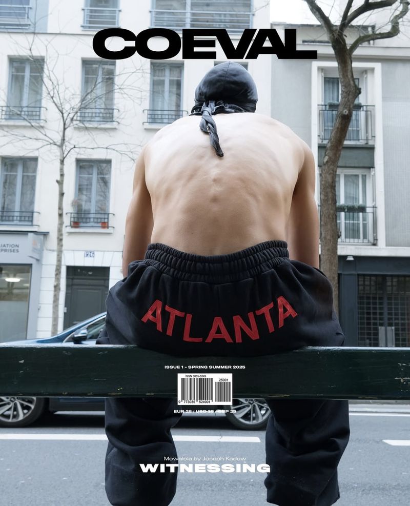 Magazine cover featuring a person sitting on a bench with buildings in the background and the word 'Atlanta' on black sweatpants.