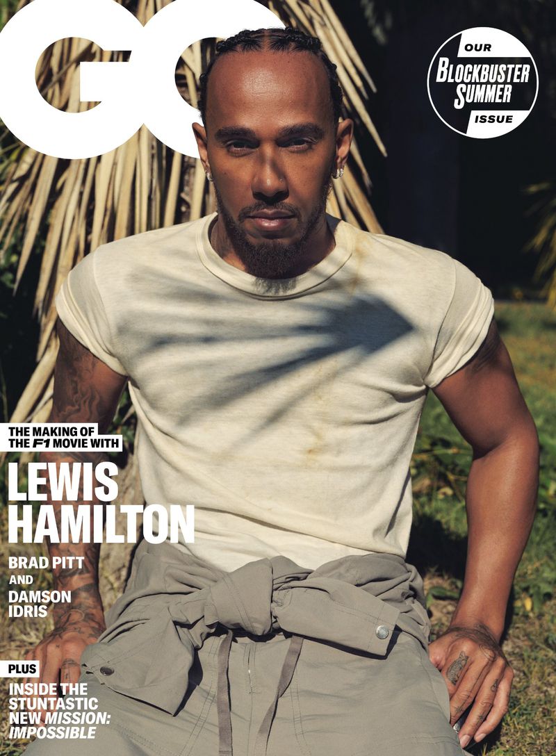 Lewis Hamilton on the cover of GQ magazine, wearing a cream t-shirt with a neutral expression in an outdoor setting with palm trees.