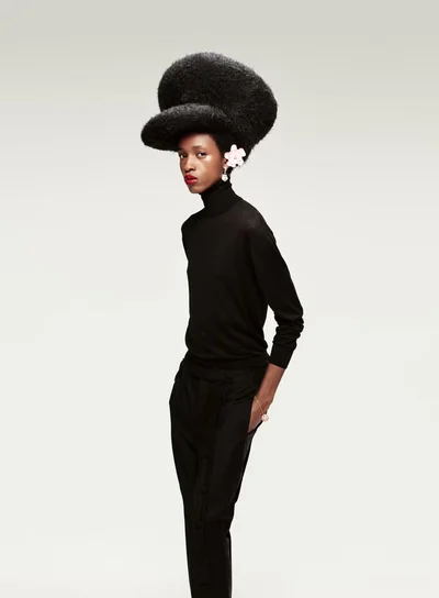 Model wearing a black turtleneck and oversized textured hat against a white seamless background for Elle U.S.