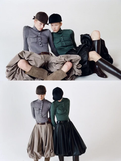 Two fashion models pose in a studio wearing riding caps, form-fitting tops, and distinctive skirts, exhibiting a high-fashion equestrian style.